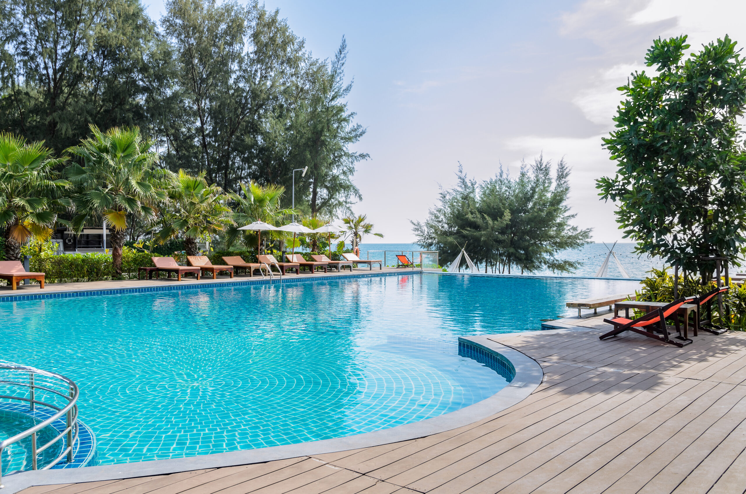 Sea view swimming pool with sun lounges on side, clean and clear turquoise water